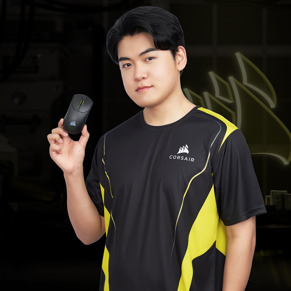 Esports pro Gumayusi wearing a CORSAIR jersey holds a CORSAIR gaming mouse against a dark background.