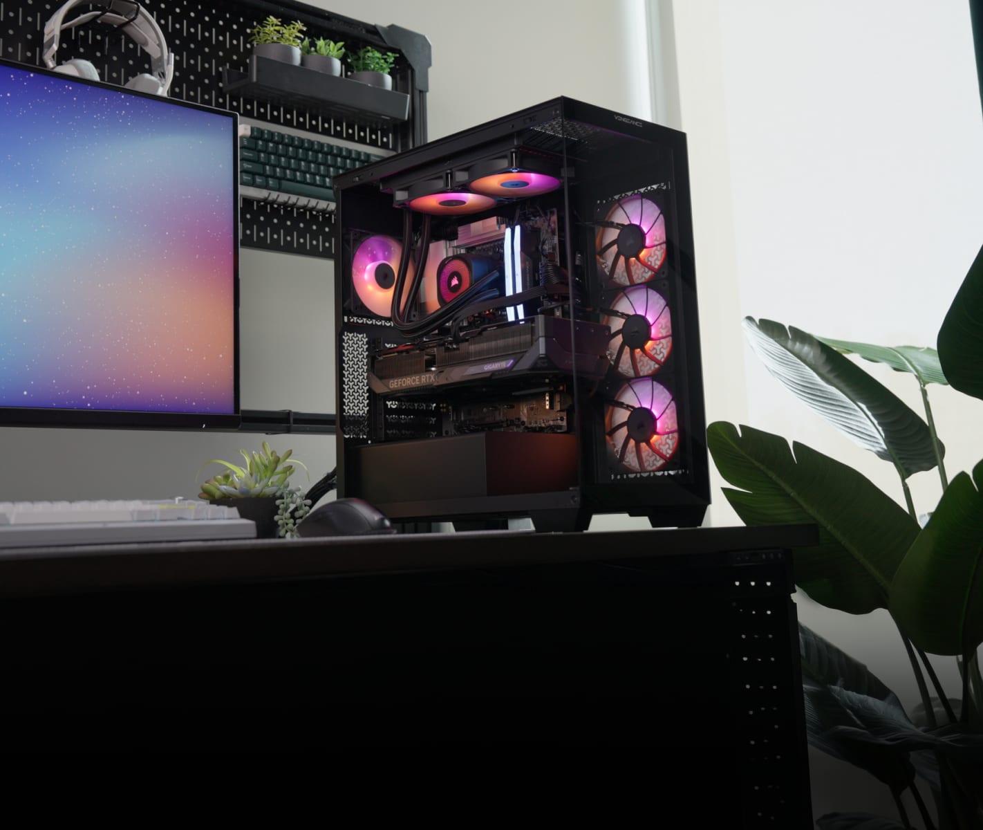 Corsair Vengeance a7500 gaming PC on a home desk with RGB lighting, AIO cooler, and case fans visible through the tempered glass panel.