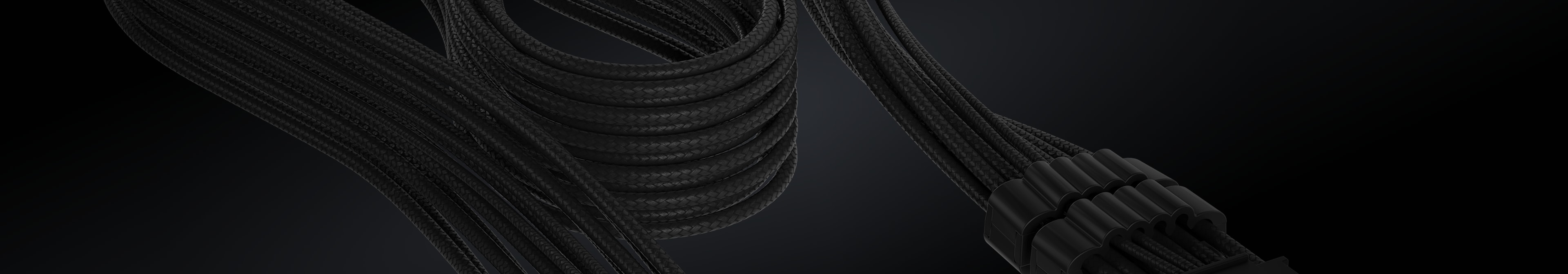 Close-up of a black sleeved CORSAIR PSU cable neatly coiled, with an 8-pin connector visible against a dark background.