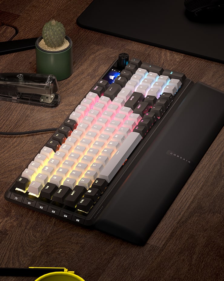 CORSAIR Vanguard 96 mechanical gaming keyboard with multicolor RGB lighting on a wooden desk with wrist rest.