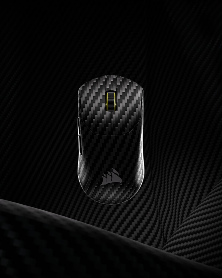 CORSAIR SABRE PRO v2 WIRELESS CF gaming mouse with carbon fiber finish on a dark carbon fiber textured background.