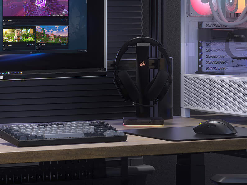 CORSAIR gaming desk setup with headset on stand, keyboard, mouse, and RGB PC tower for Special Offers homepage tile.