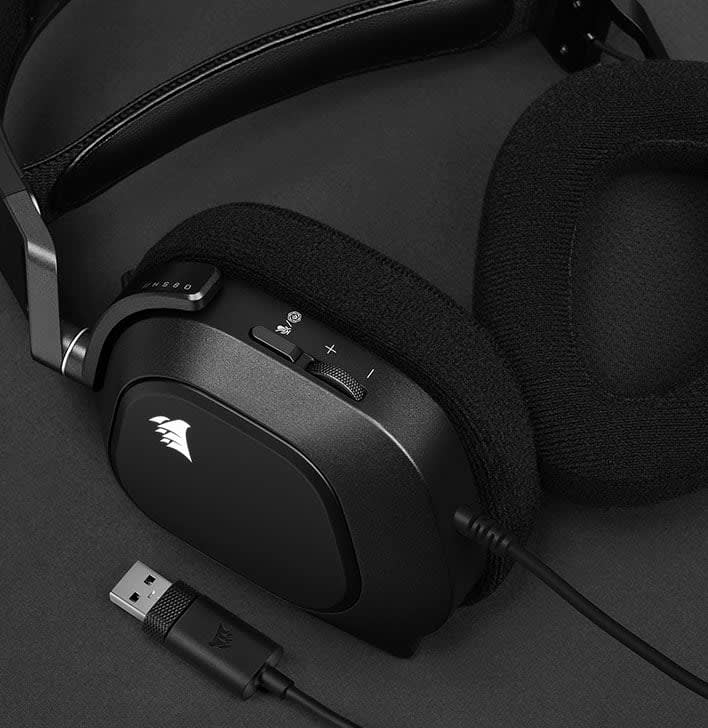 HS80 RGB USB headset lying on a flat surface with one earcup turn to show the memory foam ear pads.