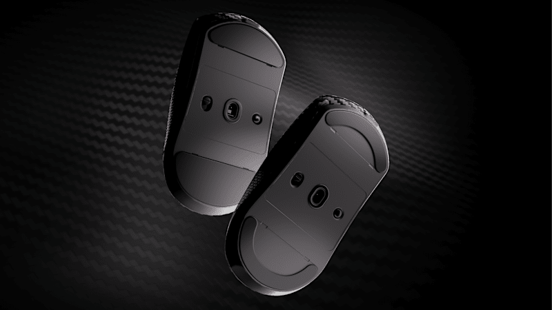 Two CORSAIR SABRE v2 WL CF gaming mice shown bottom-up, highlighting the replaceable PTFE mouse skates and sensor window.